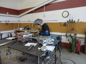 Jeff welding a golf ball holder and stand.